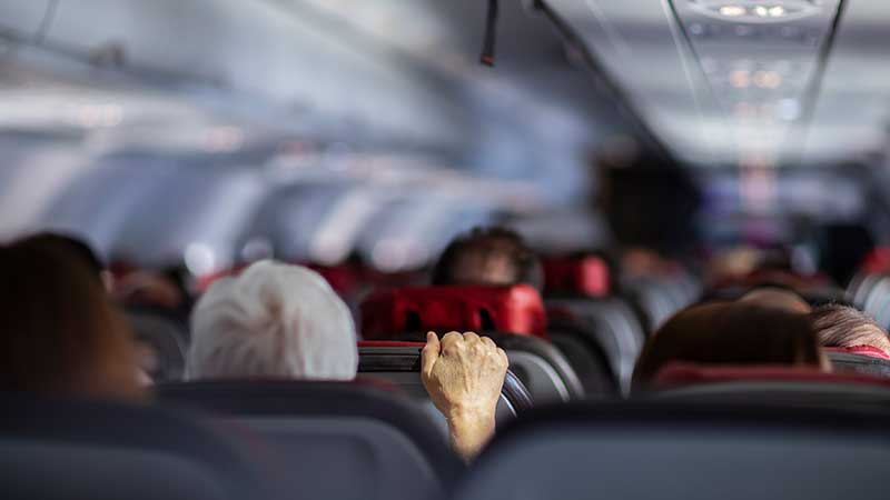 Pessoas agarrada ao banco no interior do avião